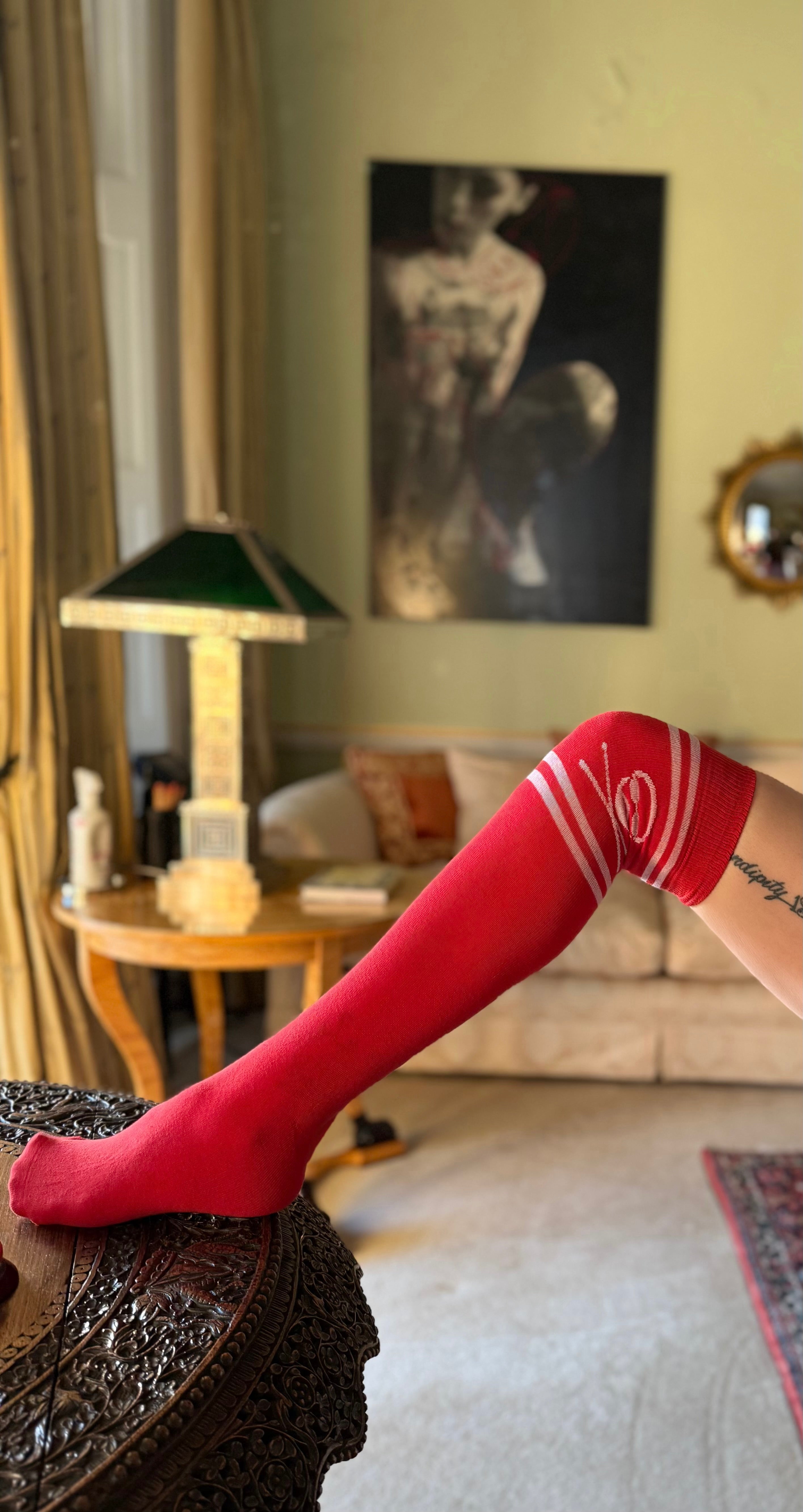 Red knee-high socks with white stripes and skull and crossbones design